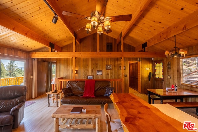 living room with ceiling fan with notable chandelier, wooden walls, lofted ceiling with beams, light hardwood / wood-style flooring, and wooden ceiling