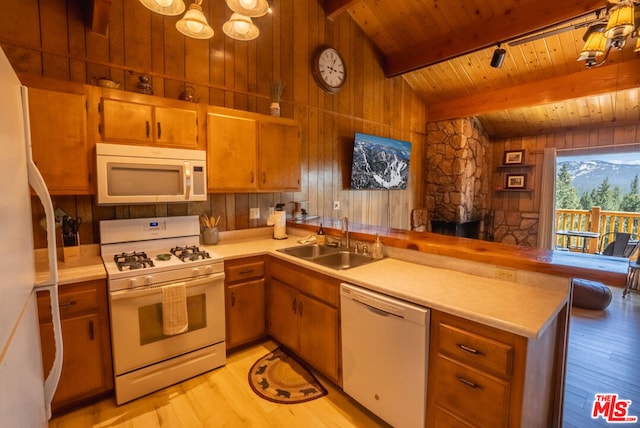 kitchen featuring kitchen peninsula, white appliances, sink, lofted ceiling with beams, and light hardwood / wood-style flooring