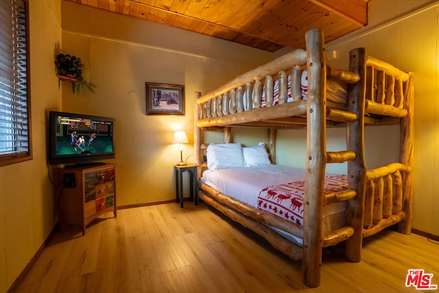 bedroom with wooden ceiling, wood-type flooring, and wood walls