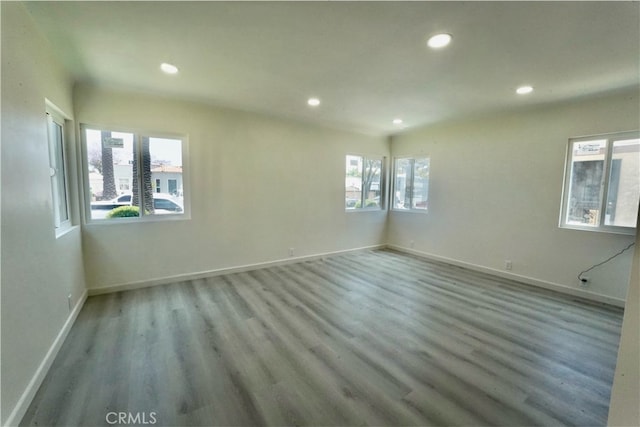 spare room featuring a wealth of natural light and hardwood / wood-style floors