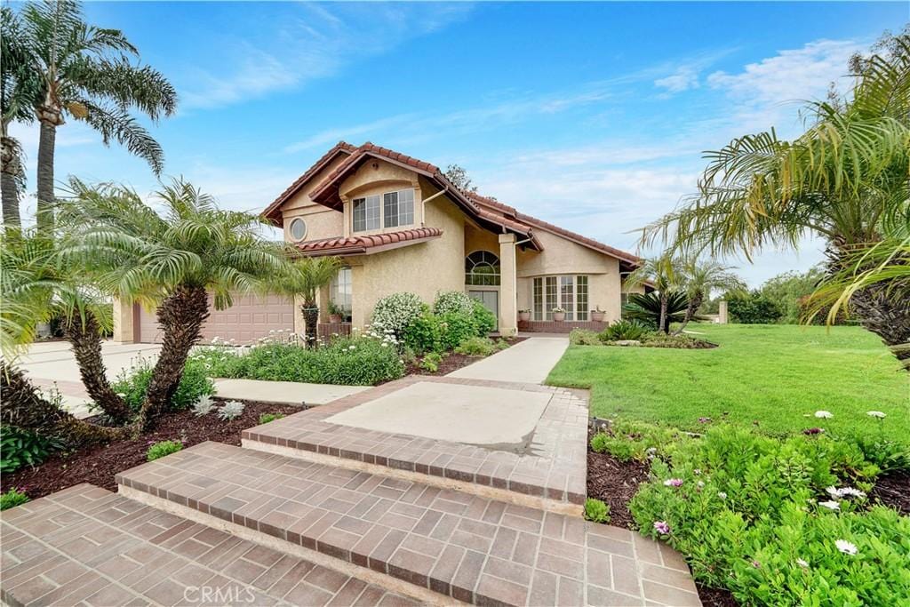 mediterranean / spanish house with a front lawn