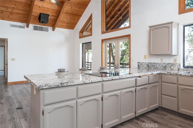 kitchen with a peninsula, wood ceiling, visible vents, and black electric cooktop