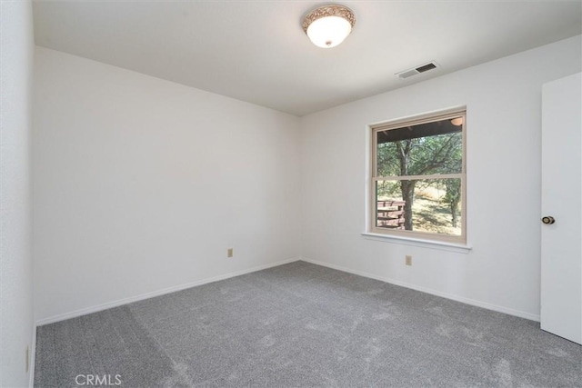 empty room with baseboards, visible vents, and carpet flooring