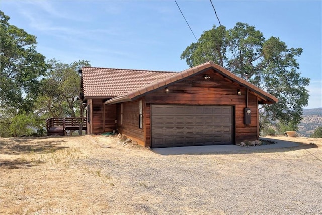 exterior space with a garage and a tile roof