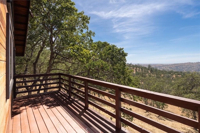 wooden terrace featuring a view of trees