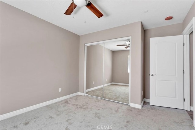 unfurnished bedroom with ceiling fan, a closet, and light colored carpet