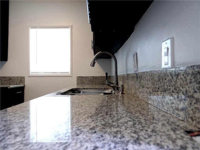 kitchen with light stone countertops and sink