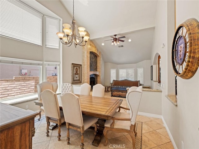 dining area with a wealth of natural light, light tile patterned floors, a large fireplace, and baseboards