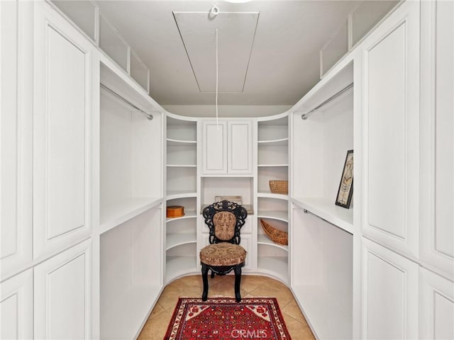 spacious closet with light tile patterned flooring and attic access