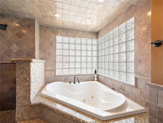 bathroom featuring tile walls and plus walk in shower