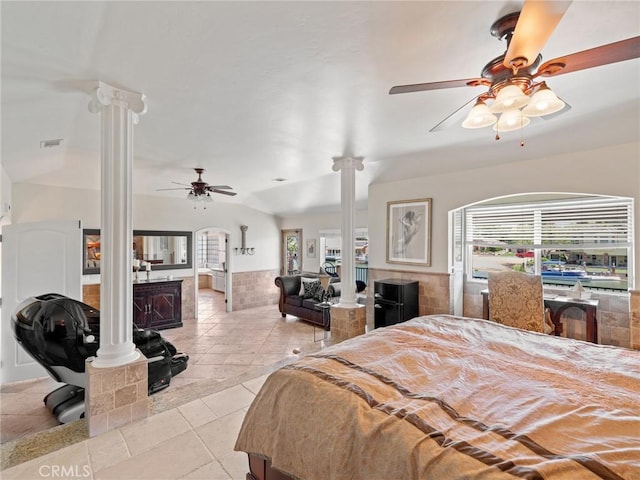 bedroom featuring vaulted ceiling, multiple windows, visible vents, and decorative columns