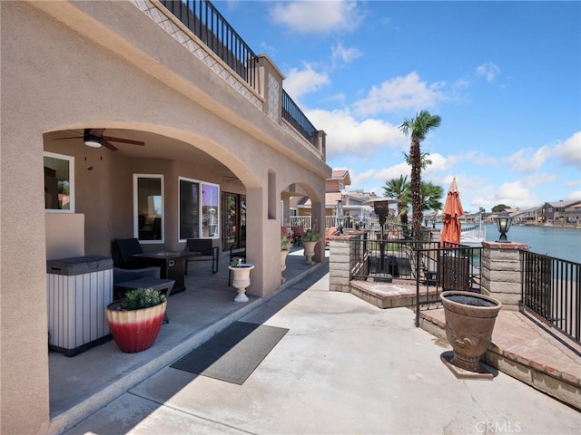 view of patio / terrace featuring a ceiling fan and a water view