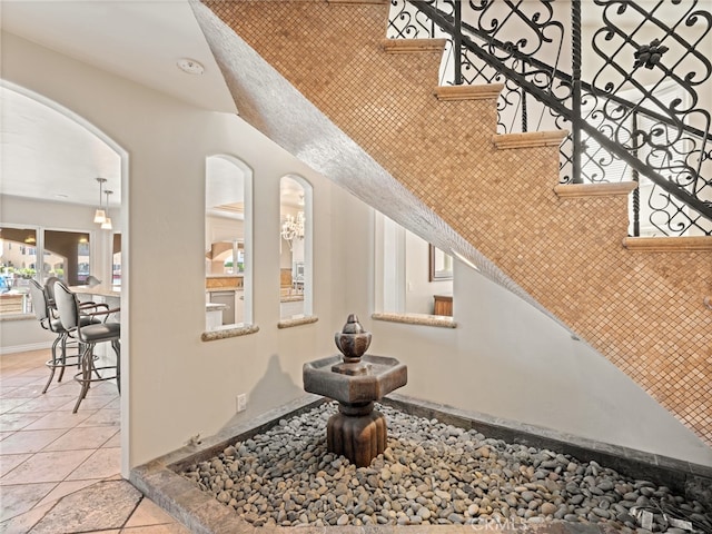 interior space with tasteful backsplash, a notable chandelier, and tile patterned floors