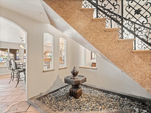 interior space featuring stairway, arched walkways, and tile patterned flooring