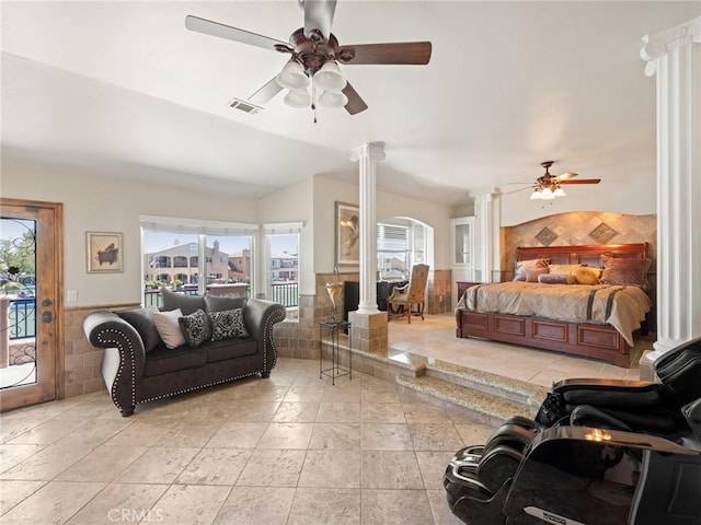 bedroom featuring visible vents, a wainscoted wall, tile walls, access to exterior, and ornate columns