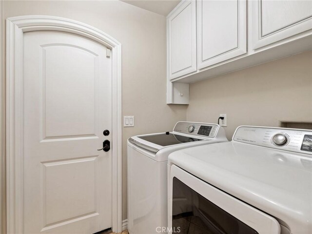 washroom with cabinets and washer and clothes dryer