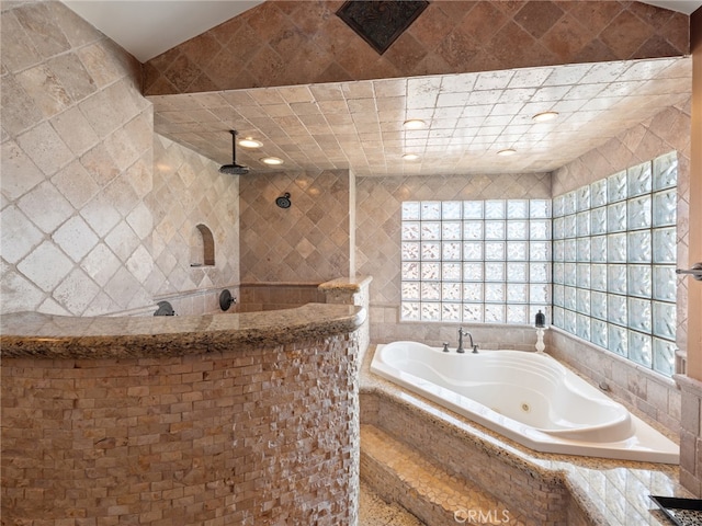 bathroom featuring tile walls and plus walk in shower