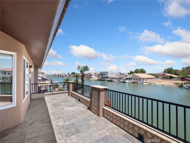 view of patio / terrace with a balcony and a water view