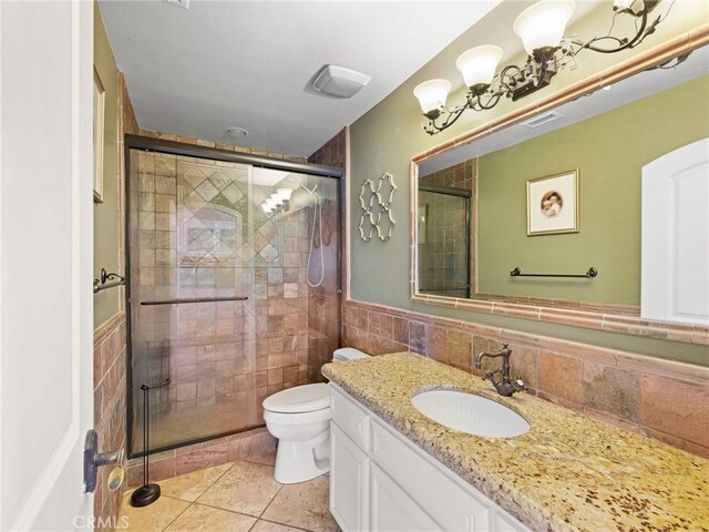 bathroom with a shower with shower door, vanity, backsplash, toilet, and tile patterned floors