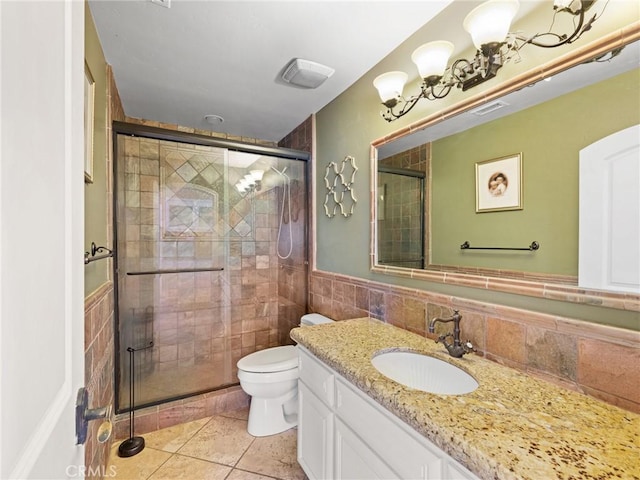 full bathroom with a wainscoted wall, toilet, a stall shower, tile walls, and vanity