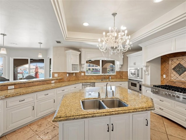 kitchen featuring white cabinetry, a tray ceiling, stainless steel appliances, and a sink