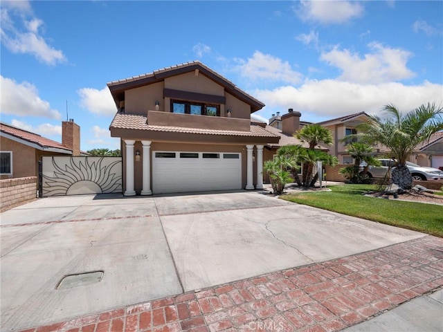 mediterranean / spanish home with stucco siding, a garage, driveway, and a tiled roof