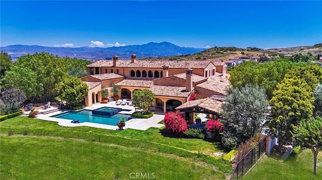 back of property with a gazebo, a mountain view, and a lawn