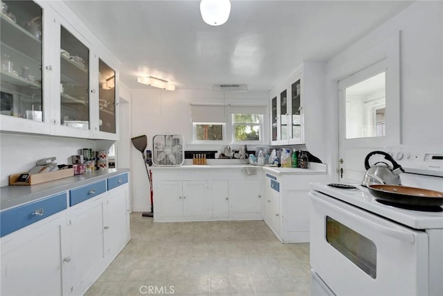 kitchen featuring white cabinets, electric range, and hanging light fixtures