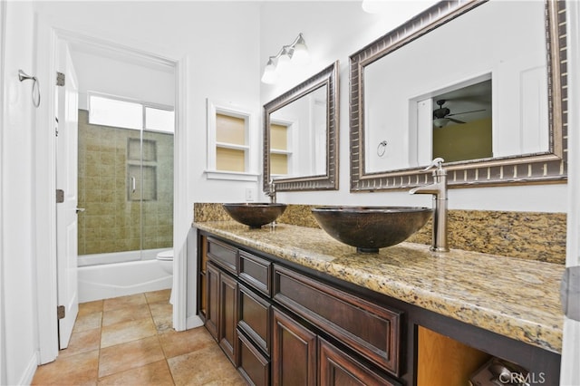 full bathroom with toilet, tile patterned flooring, vanity, combined bath / shower with glass door, and ceiling fan