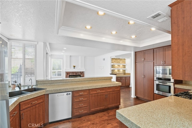 kitchen featuring a raised ceiling, a textured ceiling, stainless steel appliances, dark wood-type flooring, and ornamental molding