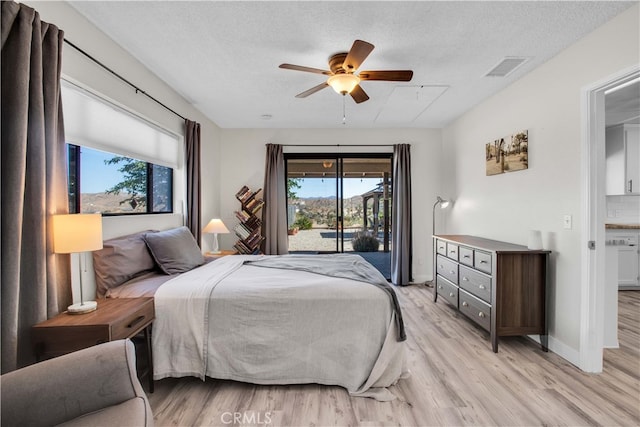 bedroom with light wood-type flooring, access to exterior, and multiple windows