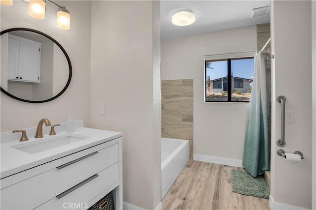 bathroom with wood-type flooring, vanity, and shower / bath combo