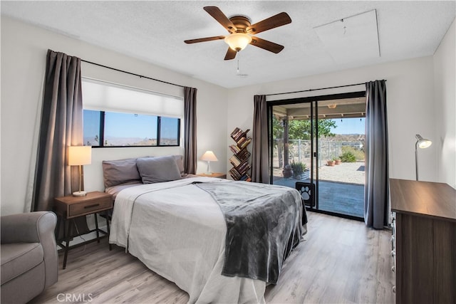 bedroom featuring light wood-type flooring, access to outside, ceiling fan, and a textured ceiling