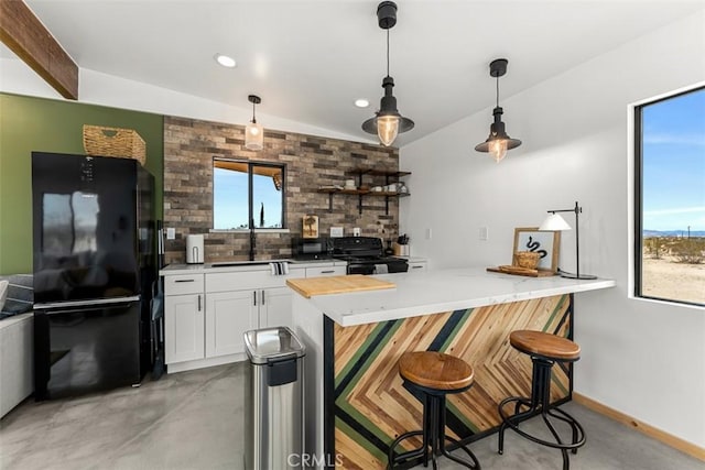 65154 Hoover Rd, Joshua Tree, CA 92252 - kitchen featuring black appliances, tasteful backsplash, white cabinets, a peninsula, and a kitchen breakfast bar
