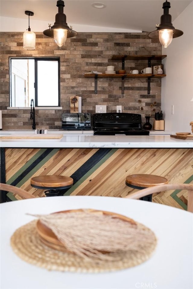 bar featuring tasteful backsplash, black range oven, and pendant lighting