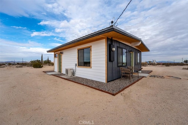 view of side of home with ac unit