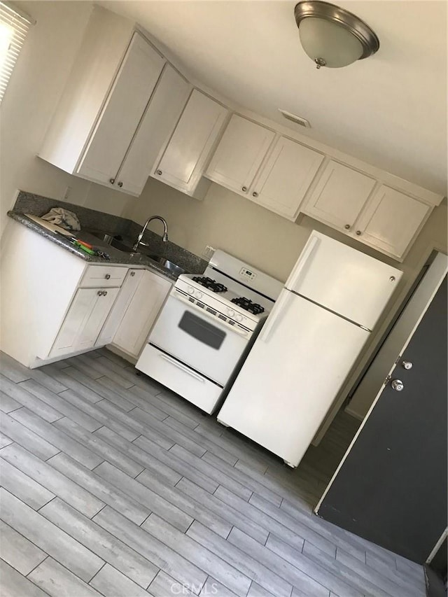 kitchen with sink, white cabinets, light wood-type flooring, and white gas range oven