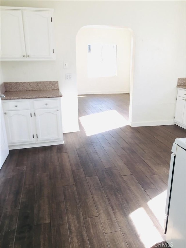 kitchen featuring white cabinets, dark wood-type flooring, and range