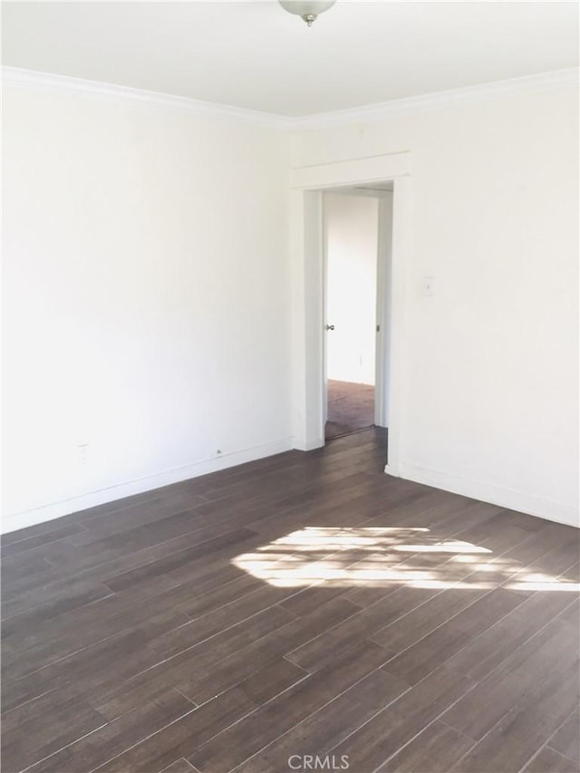 spare room featuring crown molding and dark wood-type flooring