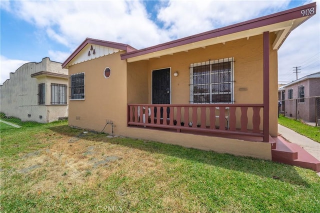 rear view of house featuring a yard