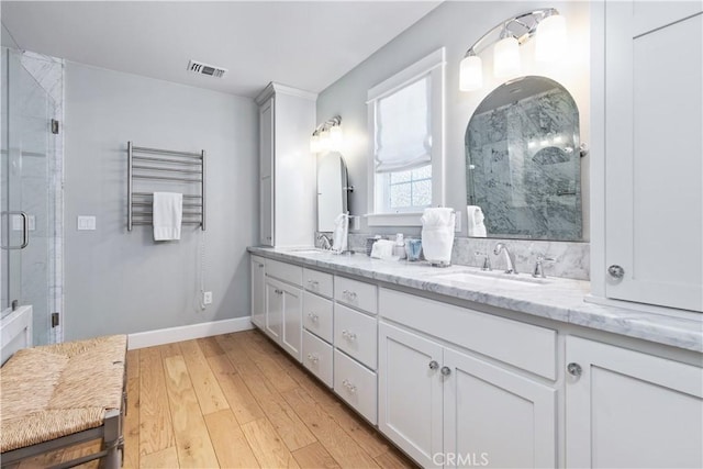 bathroom featuring hardwood / wood-style floors, vanity, and walk in shower