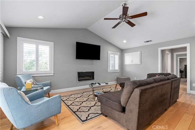 living room with ceiling fan, light wood-type flooring, and lofted ceiling