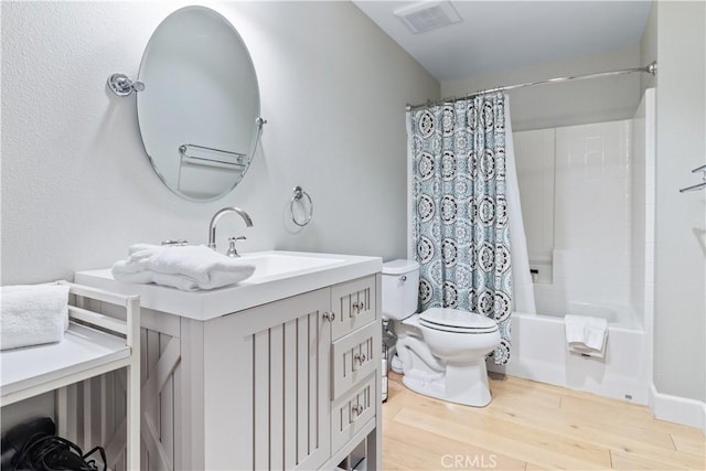 full bathroom featuring vanity, wood-type flooring, shower / tub combo, and toilet