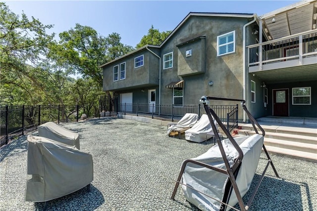 back of property with a balcony and a garage