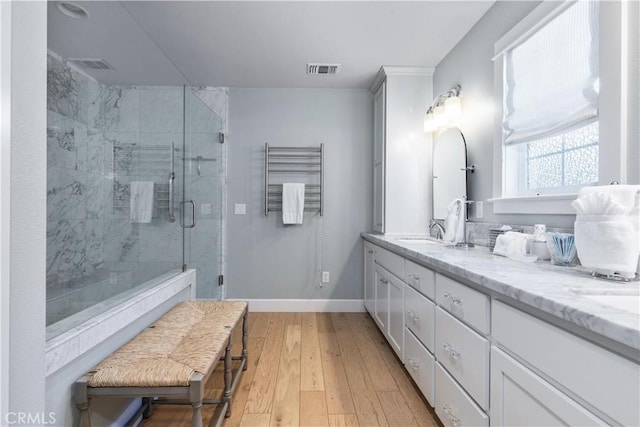 bathroom featuring vanity, wood-type flooring, and walk in shower