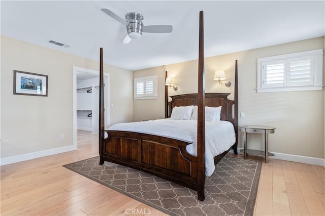 bedroom featuring hardwood / wood-style floors, ceiling fan, and multiple windows