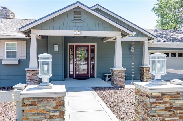 doorway to property featuring covered porch and a garage