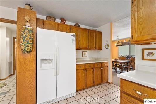 kitchen featuring white refrigerator with ice dispenser and light tile patterned flooring