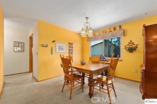 carpeted dining area featuring an inviting chandelier