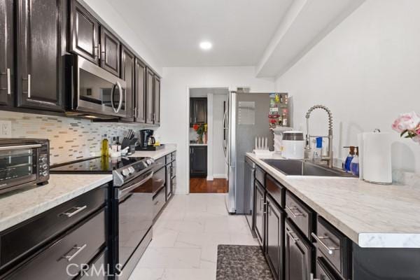 kitchen featuring decorative backsplash, dark brown cabinetry, stainless steel appliances, and sink